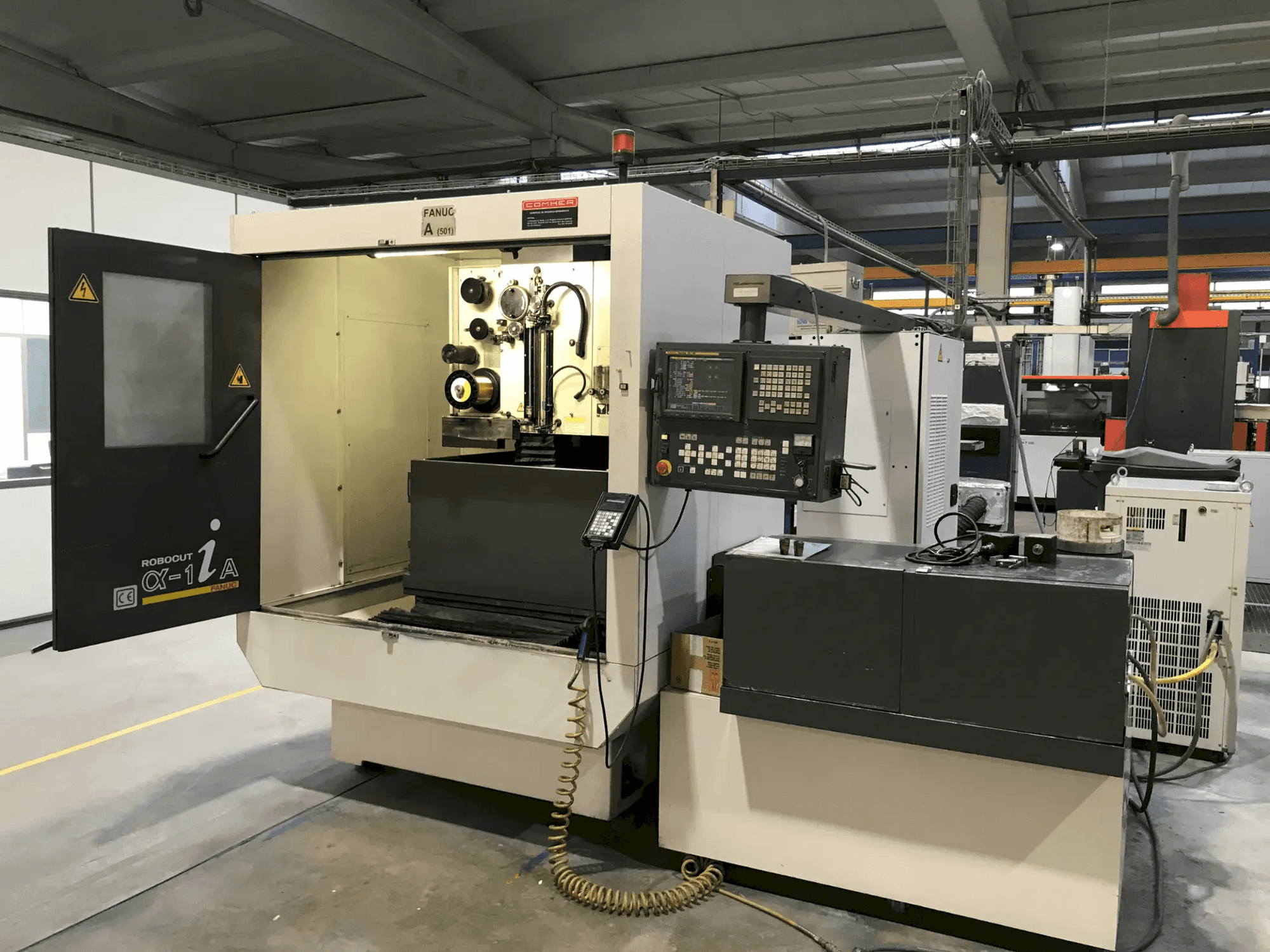 Mazak Vertical Machining Centre with open door showing tools and controls, side view, for precision machining applications.