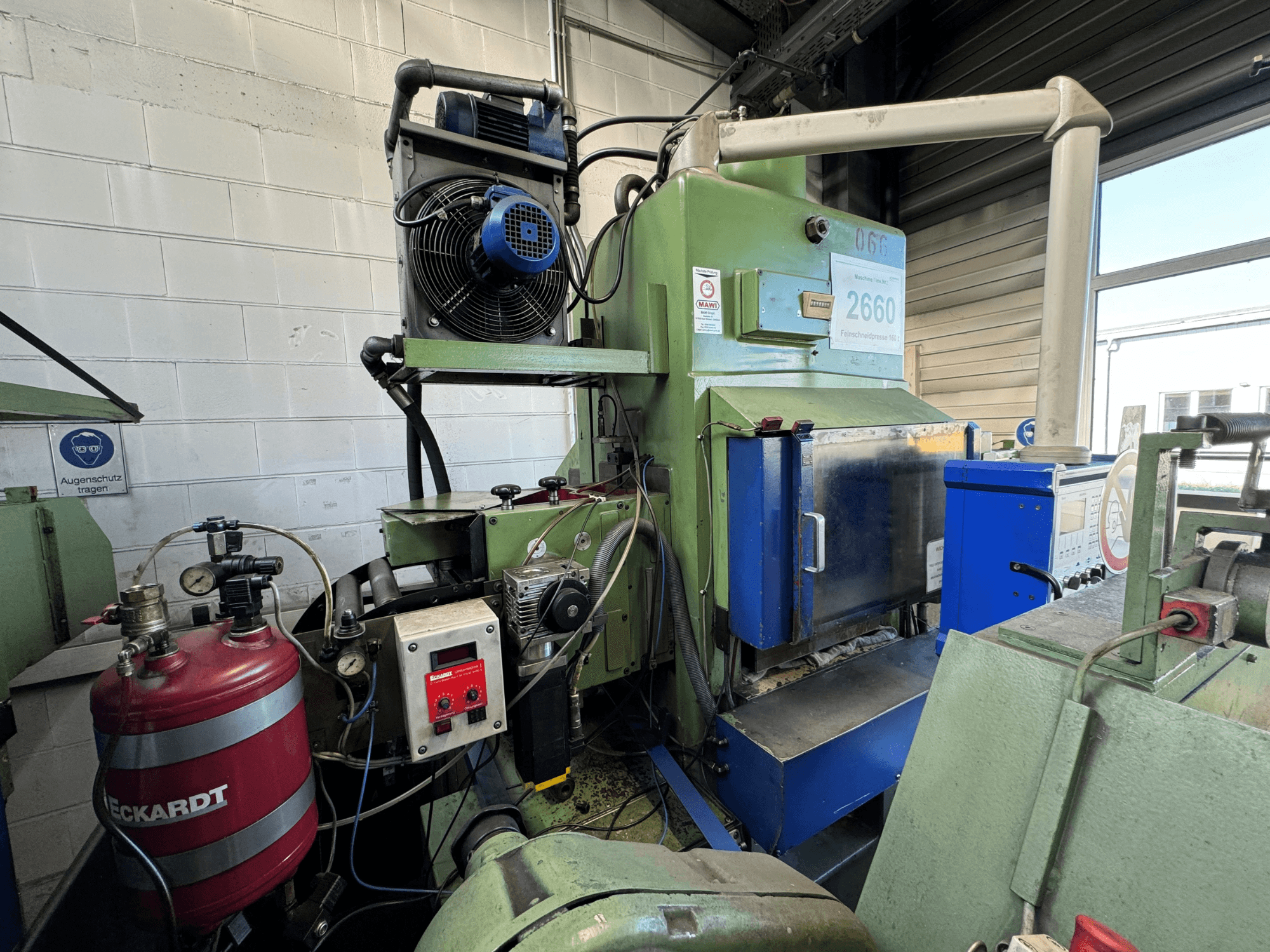 Green industrial machine with blue panel, fan mounted, control dials, and a red tank labeled "ECKARDT," front view.